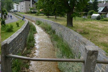 Upravený úsek Loučského potoka s navýšenými ochrannými zídkami